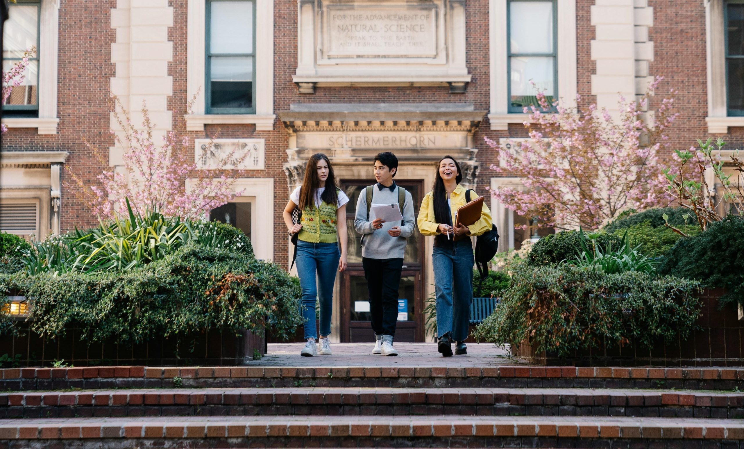 Etudiant de secondaire sortant de leur école avec leur sac sur le dos et des livres de cours à la main